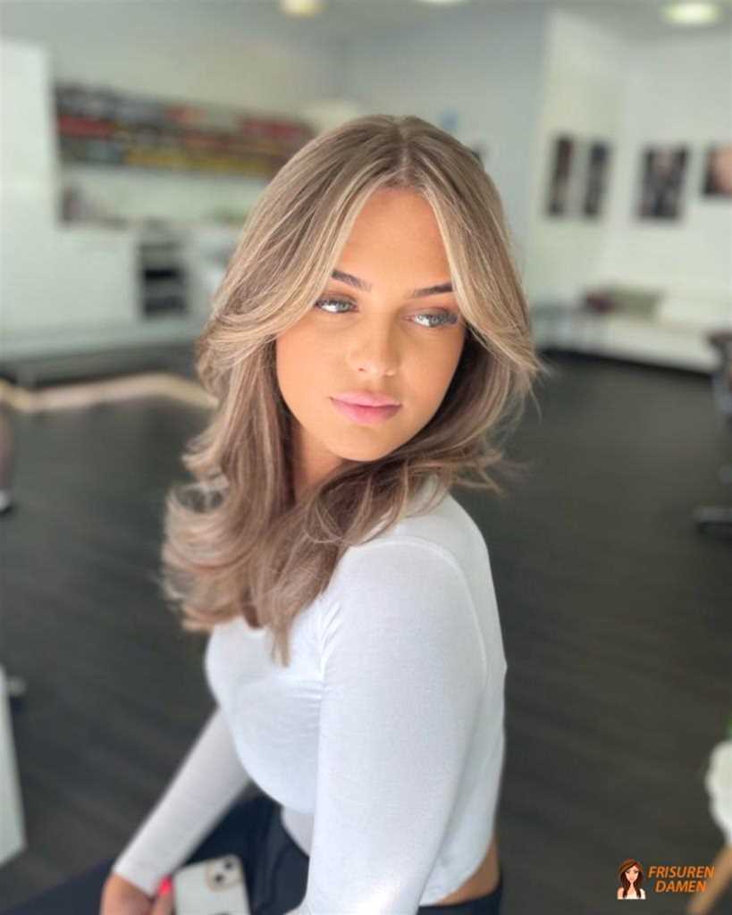 Glänzende Längen mit dezenten kühlen blonden Strähnen für Frauen, feine Highlights und moderner Glanz