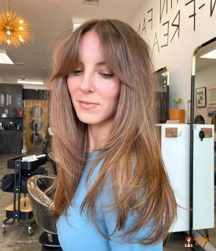 Curtain Bangs Frisur in warmen Erdtönen für einen romantischen Look bei Frauen